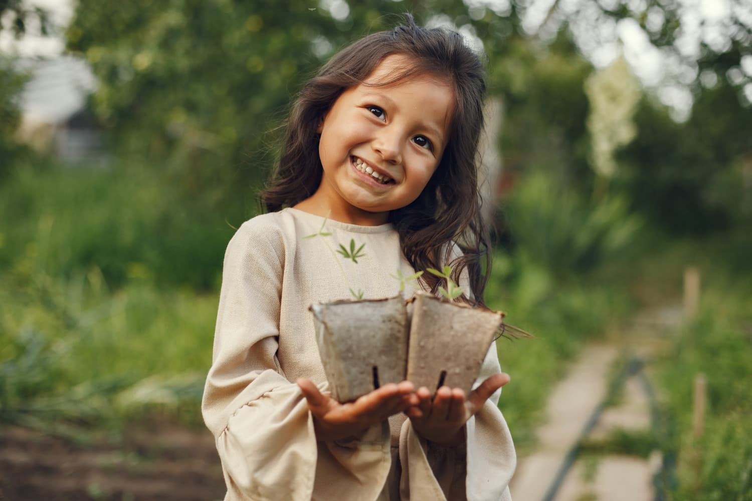 child-girl-holding-seedlings-ready-be-planted-ground-little-gardener-brown-dress (1)